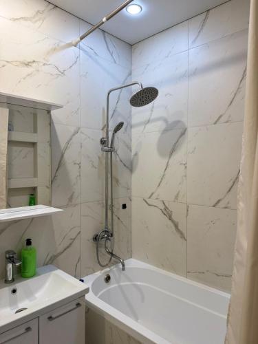 un bagno con doccia, vasca e lavandino di Трехкомнатная квартира с хорошим ремонтом a Almaty
