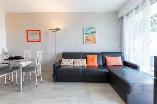 un salon avec un canapé noir et une table dans l'établissement Florida 35m studio sea view closed to the Croisette, à Cannes