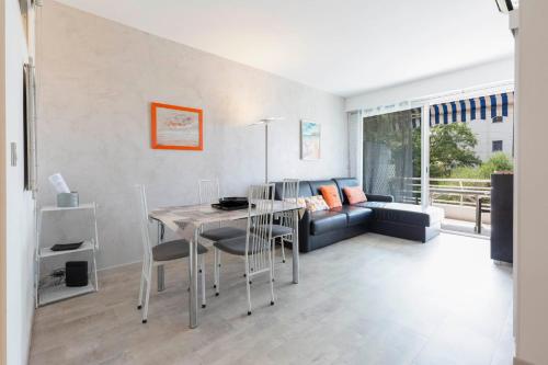 un salon avec une table et un canapé dans l'établissement Florida 35m studio sea view closed to the Croisette, à Cannes