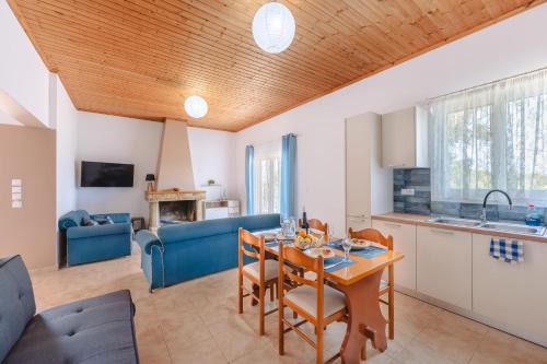a kitchen and living room with a table and chairs at To Pournari Beachside Garden House - Happy Rentals in Korakokhórion