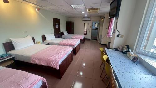 a hotel room with three beds and a counter at Magaixian Homestay in Dongyin