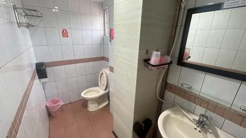 a bathroom with a toilet and a sink at Magaixian Homestay in Dongyin