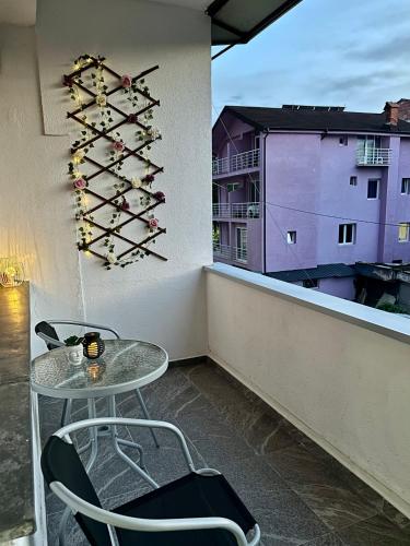 a table and chairs on a balcony with wine racks at Lakeside apartment in Struga