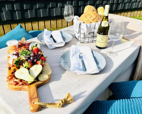 a table with a plate of food and a bottle of wine at Brora Escapes in Brora