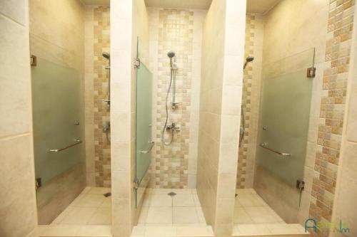 a bathroom with a shower with glass doors at Armenian Inn in Yerevan