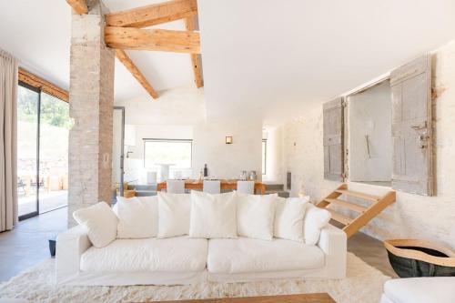 un salon avec un canapé blanc et une cuisine dans l'établissement La Bergerie Ferme du Montaiguet, à Aix-en-Provence