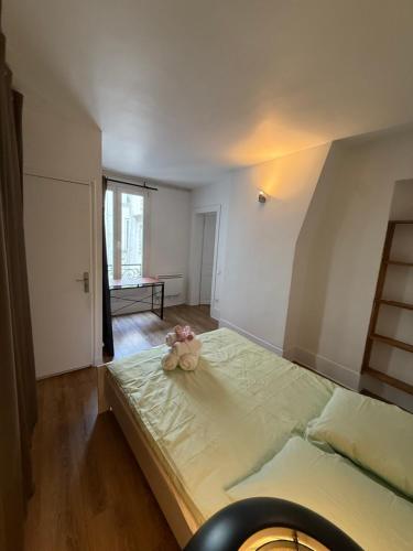 une chambre avec un lit avec un animal en peluche dessus dans l'établissement Appartement au centre de Paris, à Paris