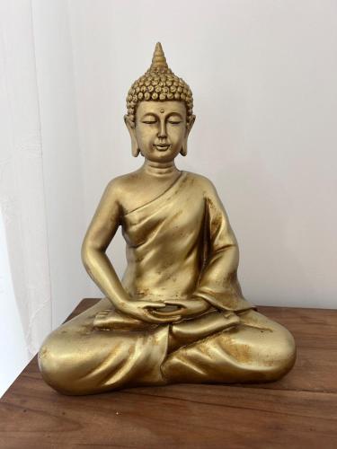 a golden buddha statue sitting on a table at Brighton Rock Retreat in Brighton & Hove