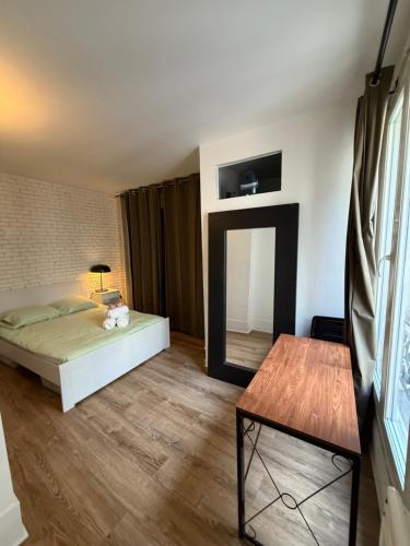 une chambre avec un lit, un miroir et une table dans l'établissement Appartement au centre de Paris, à Paris