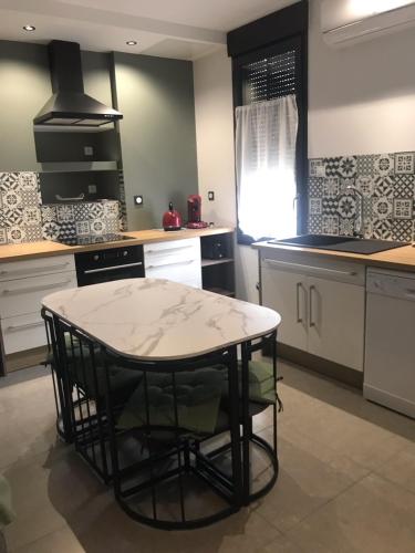 une cuisine avec une table au milieu dans l'établissement Escale détente, à Vayres