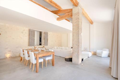 une salle à manger avec une table et des meubles blancs dans l'établissement La Bergerie Ferme du Montaiguet, à Aix-en-Provence