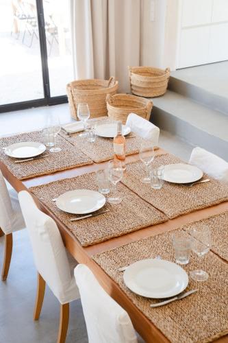 - une table avec des assiettes blanches et des verres à vin dans l'établissement La Bergerie Ferme du Montaiguet, à Aix-en-Provence