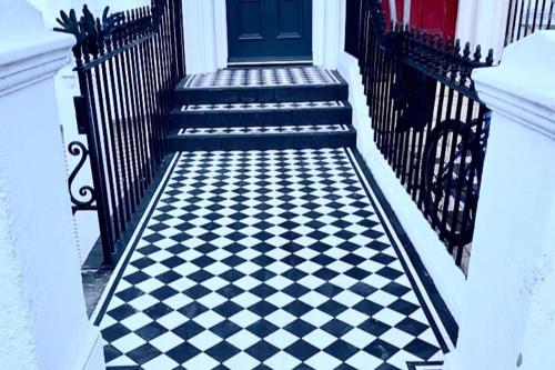a black and white checkered staircase with a blue door at Brighton Rock Retreat in Brighton & Hove