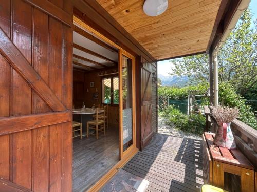 a wooden house with a wooden door and a porch at Horizon Nature - WIFI - Jardin in Jausiers