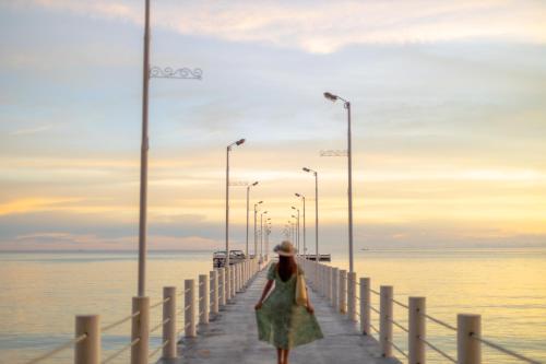 a woman walking on a pier near the water at Mafiya Resort in Koh Rong Island