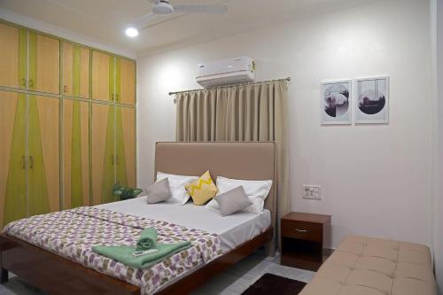 ein Schlafzimmer mit einem Bett mit zwei grünen Handtüchern darauf in der Unterkunft Siddhartha Enclave 3bhk-Madhapur, Hyderabad in Hyderabad