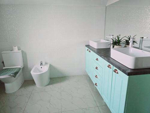 a bathroom with a toilet and a sink and a urinal at Villa Magnolia in Ipoteşti