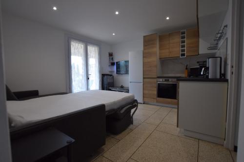 une chambre avec un grand lit et une cuisine dans l'établissement SETTE B Locations T3 Bas Villa, à Cavalaire-sur-Mer