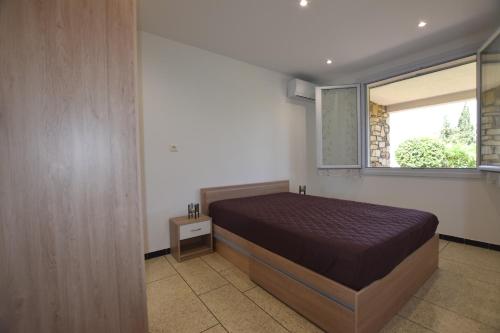 une chambre avec un lit et une fenêtre dans l'établissement SETTE B Locations T3 Bas Villa, à Cavalaire-sur-Mer