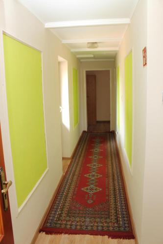 a hallway with green walls and a red carpet at Agropensjonat Stręgielek in Stręgielek