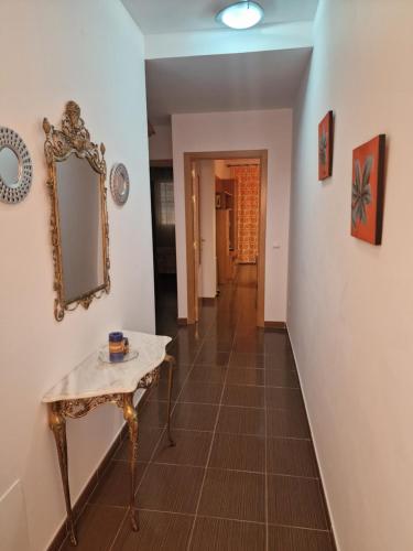 a hallway with a table and a mirror on a wall at apartamento los montes in Ruidera