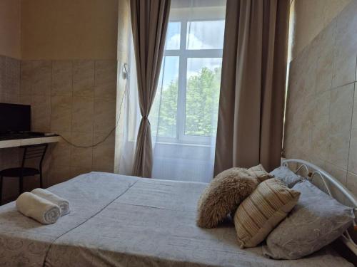 a bedroom with a bed with pillows and a window at Dream Apartments in Kyiv