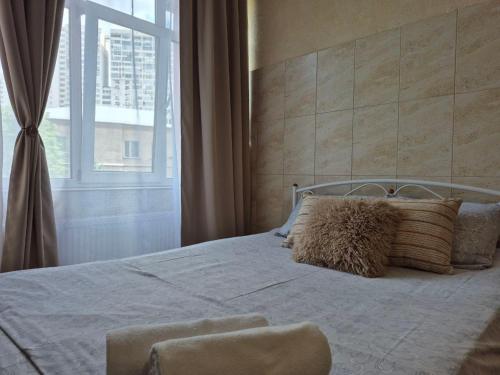a bedroom with a bed with pillows and a window at Dream Apartments in Kyiv
