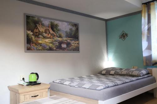 a bed in a room with a painting on the wall at Pokoje Gościnne in Niedzica Zamek