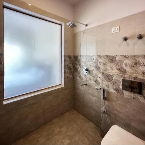 un bagno con doccia e ampia finestra di Mountain muse bnb a Leh