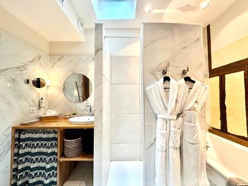 La salle de bains est pourvue d'une douche et d'un peignoir sur un portant. dans l'établissement LA SUITE 48, à Châlons-en-Champagne