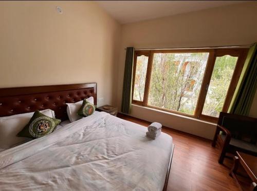 una camera da letto con un letto grande e una finestra di Mountain muse bnb a Leh