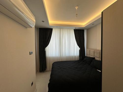 a small bedroom with a bed and a window at RUBİN Residence in Alanya
