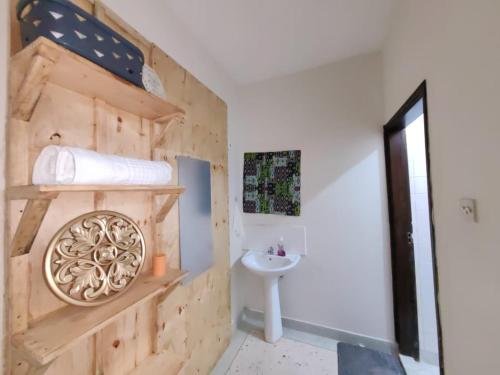 Un baño con lavabo y pared de madera. en Terry Homes, en Mombasa