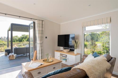 a living room with a couch and a television at Seaham Hall and Serenity Spa in Seaham