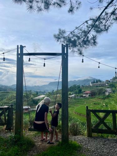 a woman and a child sitting on a swing at Pea homestay in Sa Pa
