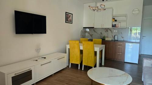 a kitchen and dining room with a table and yellow chairs at Apartments Villa Joja in Međugorje