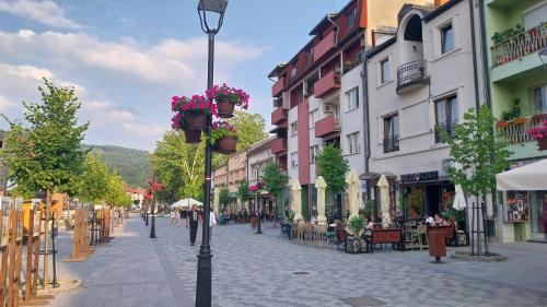 a city street with tables and chairs and a street light at Hacijenda in Bajina Bašta