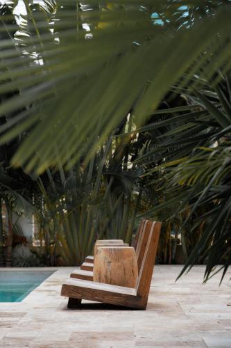 a wooden bench sitting next to a pool at Hotel Anilevich Mansion in Beer Sheva