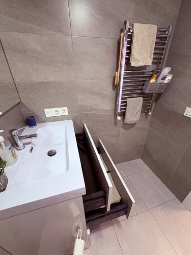 Un baño con lavabo blanco y ducha. en Apartamento Céntrico , Cómodo, Tranquilo y con WiFi, en Salamanca