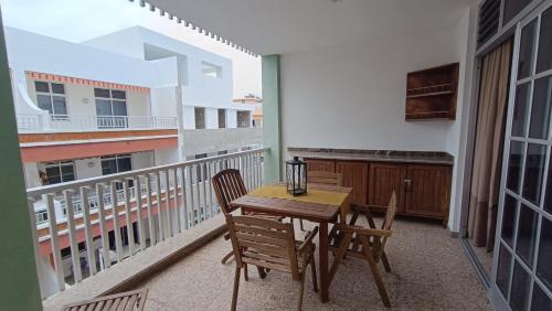 Un balcón con una mesa y sillas de madera en un balcón. en Casa Naos, en Puerto Naos