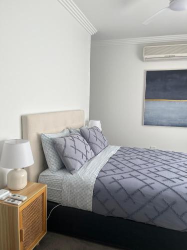 a bedroom with a bed and a table with a lamp at Family home central to everything in Mildura
