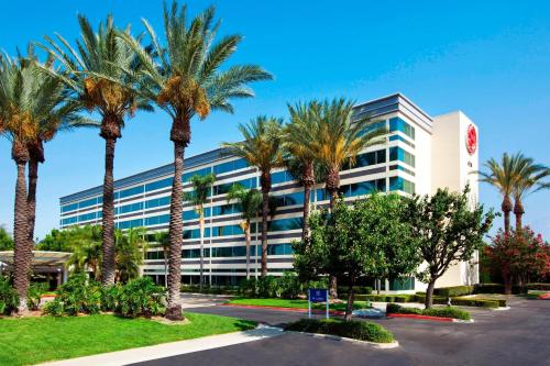 a building with palm trees in front of it at Sheraton Ontario Airport Hotel in Ontario