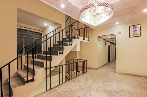 a staircase in a house with a chandelier at Hotel O Pearl City in Vidya Nagar