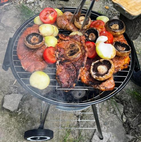a barbecue grill with meat and vegetables on it at Na samotě u lesa in Vsetín