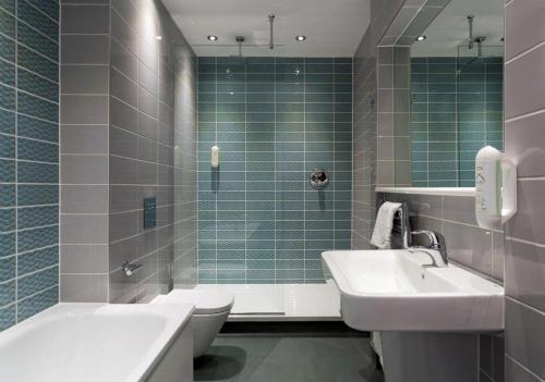 a bathroom with a sink and a toilet and a shower at The Greyhound Wetherspoon in Bridport