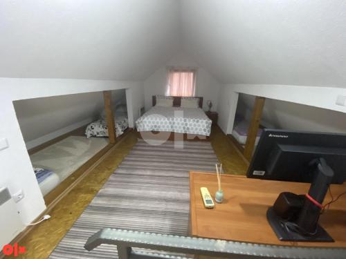 Cette petite chambre mansardée comprend un lit et une télévision. dans l'établissement Vikendica Sarah, à Tuzla