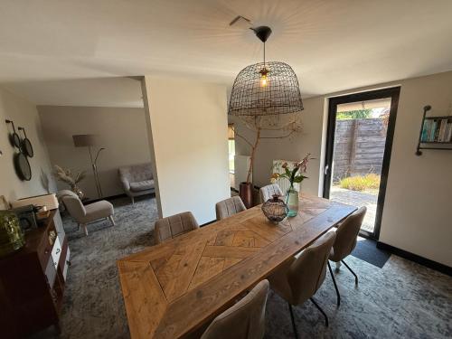 a dining room with a wooden table and chairs at Bed en Breakfast Het Oelenest in Hooghalen