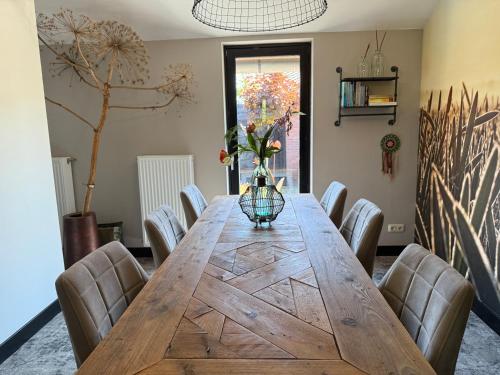 a dining room with a wooden table and chairs at Bed en Breakfast Het Oelenest in Hooghalen