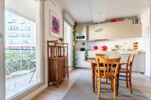 une cuisine avec une table et des chaises et une fenêtre dans l'établissement Appartement Gorge de loup, à Lyon