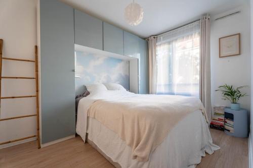 une chambre avec un lit blanc et une fenêtre dans l'établissement Appartement Gorge de loup, à Lyon